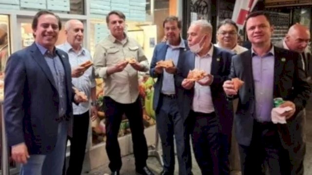 Jair Bolsonaro (3 dari kiri) memakan pizza di pinggir jalan New York (Foto: Reuters)