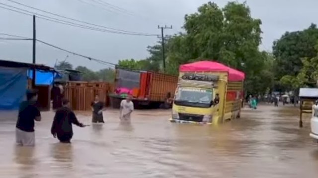 Kondisi poros Kabupaten Takalar menuju Kabupaten Jeneponto yang mengalami lumpuh total akibat banjir setinggi paha orang dewasa melanda usai diguyur hujan deras, Senin (21/2/2022). (foto: Ig @infotakalar)