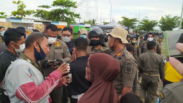 Para pedagang liar di kawasan Lego-Lego sempat menghalangi petugas yang akan mengangkut barang dagangan mereka hingga keributan sempat terjadi dengan Satpol PP Sulsel saat dilakukan penertiban, Sabtu (26/3/2022). (Abatanews/Imam Adzka)