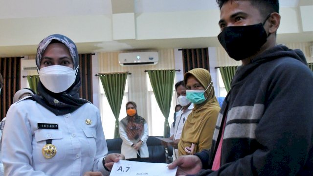 Bupati Indah menyerahkan kunci rumah huntap kepada masyarakat korban banjir bandang, di Aula Lagaligo Kantor Bupati Luwu Utara (2/3/2022). (Foto: ABATANEWS/Imam) 