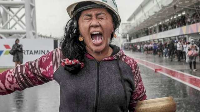 Rara Isti Wulandari saat melakukan ritual untuk memberhentikan hujan di Sirkuit Mandalika, saat balapan MotoGP ditunda akibat hujan deras. (foto/ Ig: MotoGP)