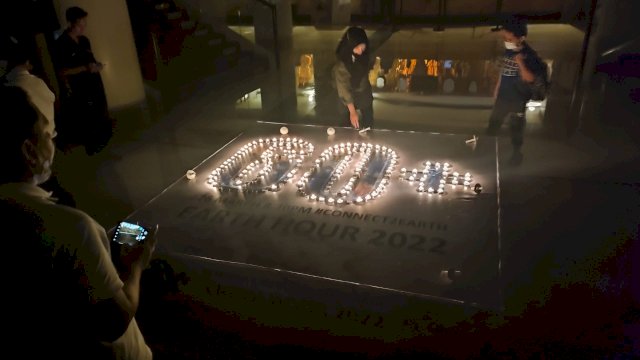 Pengunjung Hotel Claro berfoto di depan lilin berbentuk 60+, Sabtu (26/3/2022). (Foto: Abatabews/imam)