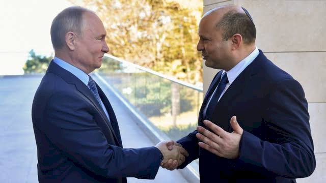 Presiden Rusia Vladimir Putin berjabat tangan dengan Perdana Menteri Israel Naftali Bennett selama pertemuan di Rusia, pada Sabtu (5/3/2022). (Foto: REUTERS) 