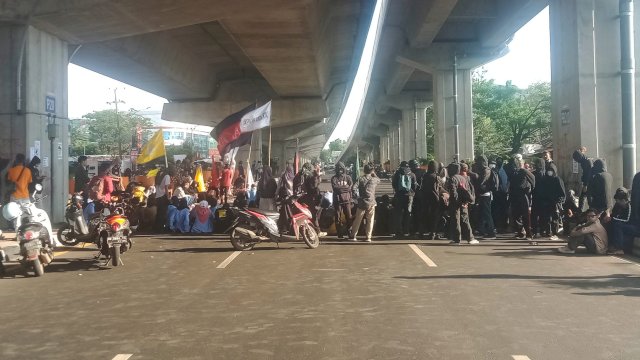 Mahasiswa memblokade Jl AP Pettarani menuju Fly Over Makassar, Senin (11/4/2022). (Abatanews/Wahyu Susanto)