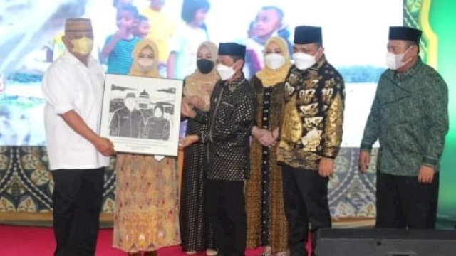 Bupati Gorontalo, Nelson Pomalingo saat memberikan penghargaan kepada Gubernur Gorontalo, Rusli Habibie dan wakilnya Idris Rahim setelah 10 tahun menjabat. (foto: abatanews)