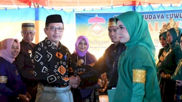 Sekretaris Kabupaten Luwu Utara (Lutra) Armiadi bersama Bupati Luwu Utara, Indah Putri Indriani saat menghadiri pengukuhan lulusan atau mappatemme sikolah peserta belajar angkatan I Sekolah Budaya Luwu I La Galigo Cabang Kabupaten Lutra di Baruga La Tamaccelling Kemakolean Baebunta, Kecamatan Baebunta, Minggu (29/5/2022). (foto: Pemkab Lutra)