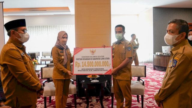 Gubernur Sulsel, Andi Sudirman menyerahkan bantuan keuangan kepada Bupati Luwu Utara, Indah Putri Indriani senilai Rp 14,5 Miliar di Baruga Lounge Kantor Gubernur Sulsel, Senin (6/6/2022).