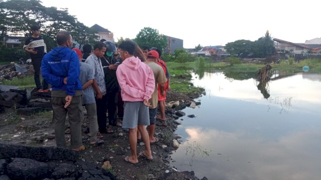 Masyarakat mengerumuni bekas proyek galian Stadion Mattoanging, Makassar di mana seorang pemuda tenggelam, Jumat (3/6/2022). (foto: Wahyu Susanto)