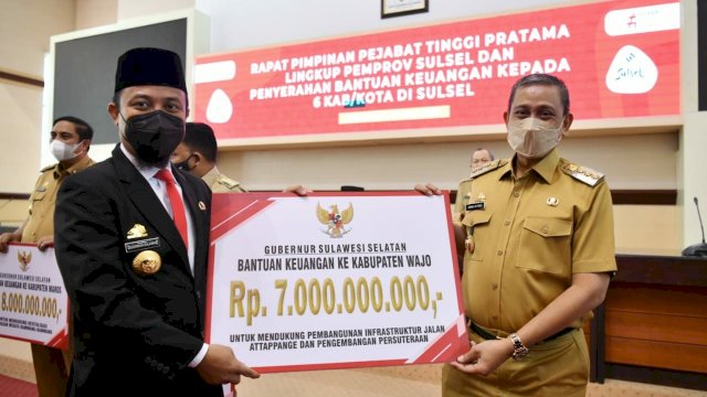 Gubernur Sulawesi Selatan, Andi Sudirman Sulaiman menyerahkan bantuan keuangan Pemprov Sulsel tahun anggaran 2022 untuk Kabupaten Wajo senilai Rp7 miliar kepada Bupati Wajo, Amran Mahmud di Ruang Rapat Pimpinan Kantor Gubernur Sulsel, pada Senin (20/6/2022).  (Foto: ABATANEWS/Wahyuddin) 