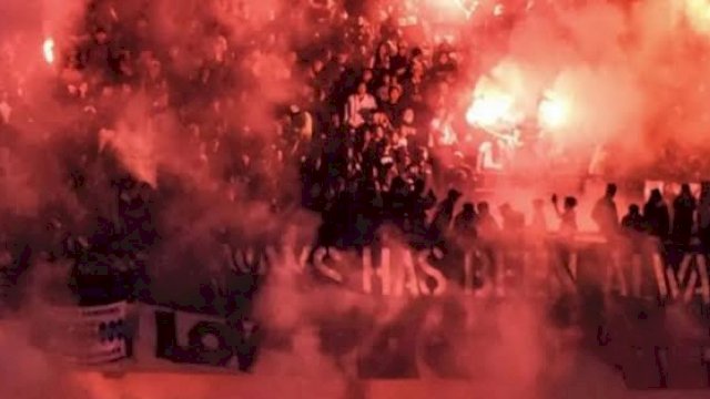 Ilustrasi suporter sepakbola di Indonesia yang menyalakan flare. (Ist)