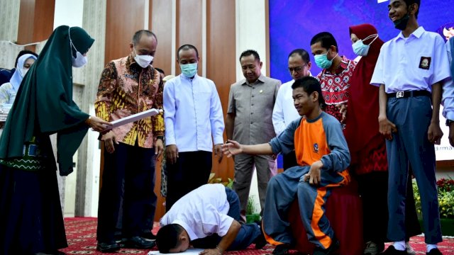 Gubernur Sulawesi Selatan, Andi Sudirman Sulaiman saat menyerahkan KTP Eletronik (E-KTP) dan Kartu Identitas Anak (KIA) kepada penyandang disabilitas. (foto: Pemprov Sulsel)