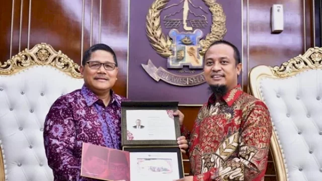 Kepala Perwakilan Bank Indonesia (BI) Sulsel, Causa Iman menyerahkan buku album berisi tujuh uang kertas dengan desain baru kepada Gubernur Sulsel, Andi Sudirman Sulaiman. (Foto: ABATANEWS/Azwar) 