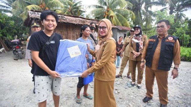 Bupati Lutra, Indah Putri Indriani saat menyerahkan bantuan ke warga korban bencana angin puting beliung. 