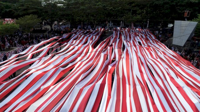 Bendera Merah Putih sepanjang 5 KM dibentangkan saat detik-detik proklamasi Kemerdekaan RI di Kota Makassar yang dipusatkan di Pantai Losari, Rabu (17/8/2022). (foto: Pemkot Makassar)