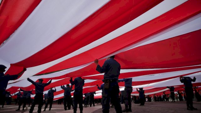 Organisasi Perangkat Daerah (OPD) Kota Makassar melakukan pembentangan bendera merah putih dalam perayaan HUT 77 RI, di Pantai Losari, Rabu (17/8/2022). (foto: Pemkot Makassar)