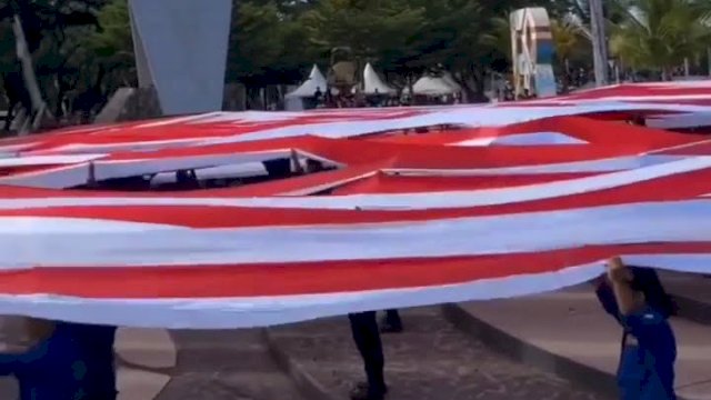 Bendera Merah Putih dibentangkan di Pantai Losari, Makassar saat upacara detik-detik proklamasi Kemerdekaan Republik Indonesia, Rabu (17/8/2022). (foto: Abatanews)