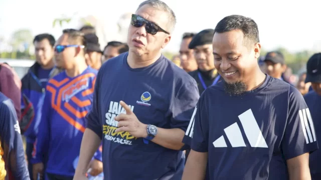 Wakil Ketua DPP NasDem Ahmad Ali berbincang dengan Gubernur Sulsel Andi Sudirman Sulaiman saat mengikut Jalan Sehat Restorasi NasDem di kawasa CPI, pada Ahad (25/9/2022) pagi. 