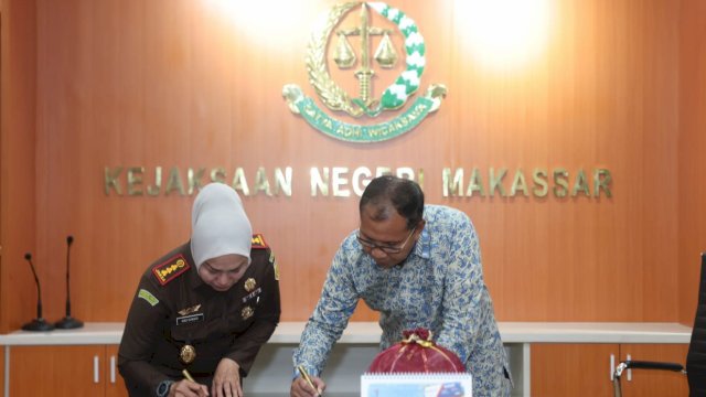 Wali Kota Makassar, Moh. Ramdhan 'Danny' Pomanto menandatangani prasasti penggunaan gedung Kejaksaan Negeri Kota Makassar pasca renovasi, Jalan Amanagappa, Rabu (12/10/2022).