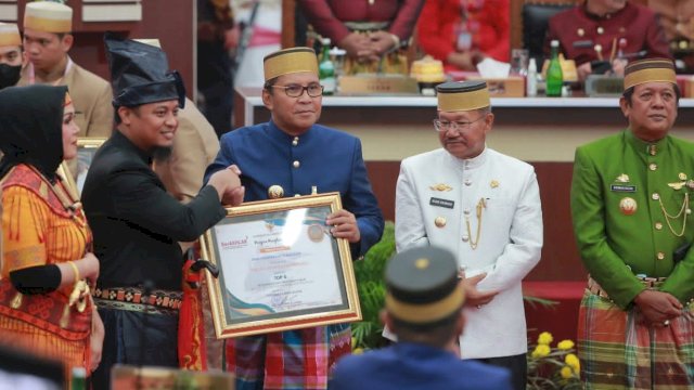 Gubernur Sulsel Andi Sudirman Sulaiman menyerahkan penghargaan kepada Wali Kota Makassar Moh Ramdhan 'Danny' Pomanto pada mementum Hari Jadi Sulsel ke-353 tahun, di Ruang Rapat Paripurna DPRD Sulsel, Rabu (19/10/2022).