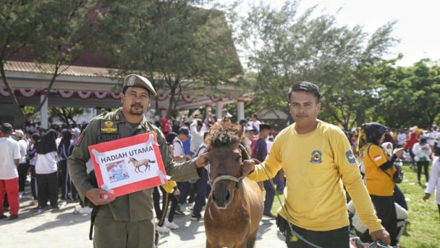 Gubernur Suslel, Andi Sudirman menyerahkan hadiah utama kuda jalan santai 'Sulsel Anti Mager' di Kabupaten Jeneponto. Gubernur Sulsel dan Bupati Jeneponto melepas peserta di Lapangan Passamaturukang, pada Selasa (25/10/2022).