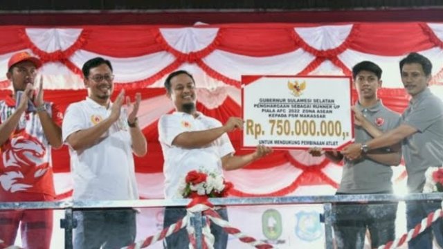 Gubernur Sulsel Andi Sudirman Sulaiman saat menyerahkan bonus untuk PSM Makassar yang diterima secara simbolis oleh Media Officer PSM Makassar, Sulaiman Abdul Karim dan pemain PSM, Ananda Raehan.