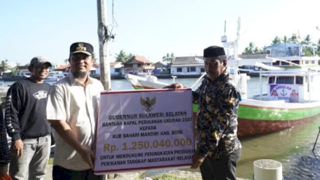 Gubernur Sulawesi Selatan (Sulsel) Andi Sudirman Sulaiman saat menyerahkan secara simbolis bantuan kapal perikanan kepada kelompok nelayan Kabupaten Bone.