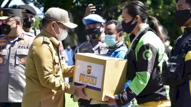 Penjabat Gubernur Gorontalo Hamka Hendra Noer bersama Kapolda Gorontalo Irjen Pol. Helmy Santika menyerahkan bantuan sosial Polda Gorontalo kepada pengemudi ojek online di Polda Gorontalo, pada Selasa (13/9/2022).