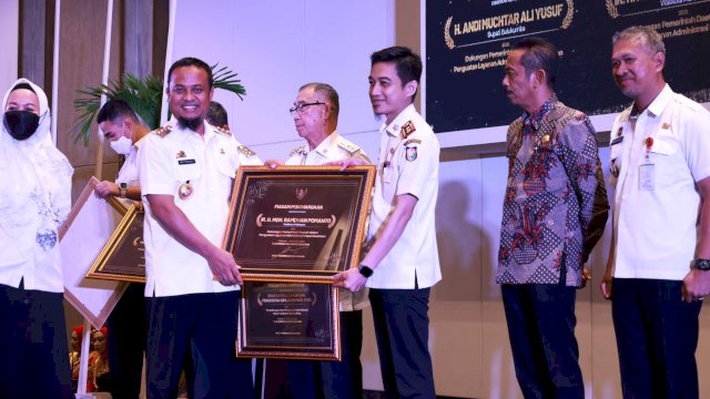 Gubernur Provinsi Sulsel, Andi Sudirman Sulaiman, saat menyerahkan penghargaan dalam acara 'Penghargaan Pencapaian Disdukcapil Provinsi Sulsel' yang digelar di Hotel Claro, Rabu (14/12/2022). 