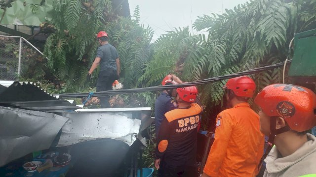 Proses evakuasi terhadap korban yang tertimpa reruntuhan bangunan setelah terjadi insiden pohon tumbang di samping gedung IMMIM, Jalan Jenderal Sudirman, Kota Makassar, Jumat (23/12/2022). 