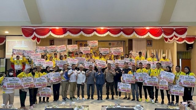 Anggota DPR RI Fraksi Golkar Muhammad Fauzi saat menyerahkan bonus kepada atlet Lutra di Aula Laga Ligo Kantor Bupati Luwu Utara. Sabtu (24/2/2022)