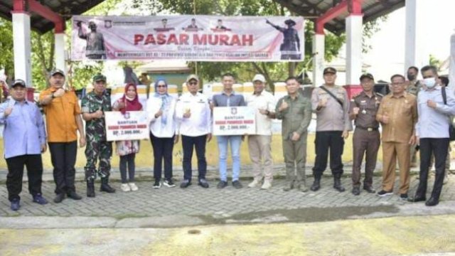 Penjagub Hamka Hendra Noer didampingi Wakil Bupati Bone Bolango dan perwakilan unsur Forkopimda saat menyerahkan secara simbolis bantuan UMKM kepada masyarakat di Suwawa pada pelaksanaan pasar murah komoditi pangan, dalam rangka HUT ke-22 Provinsi Gorontalo di Lapangan Taman Desa Boludawa, Kecamatan Suwawa Kabupaten Bone Bolango, Selasa (6/12/2022).