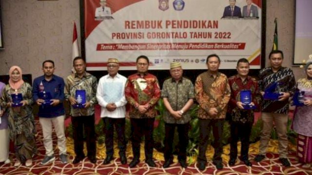 Penjabat Gubernur Gorontalo Hamka Hendra Noer, Kepala Dinas Kebudayaan Pemuda dan Olahraga Provinsi Gorontalo dan guru – guru pemenang kegiatan Hari Guru Nasional ke 77 tahun 2022 di Ballroom Hotel Grand Q, Kota Gorontalo, Senin (12/12/2022).