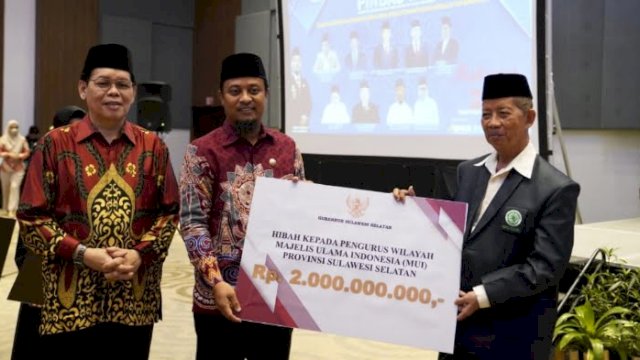 Gubernur Sulsel Andi Sudirman Sulaiman saat menyerahkan secara simbolis dana hibah dari Pemprov Sulsel untuk MUI Sulsel dalam Rapat Koordinasi Nasional Pusat Inkubasi Bisnis Syariah (PINBAS) Majelis Ulama Indonesia (MUI) di Four Point by Sheraton, Minggu, 4 Desember 2022.