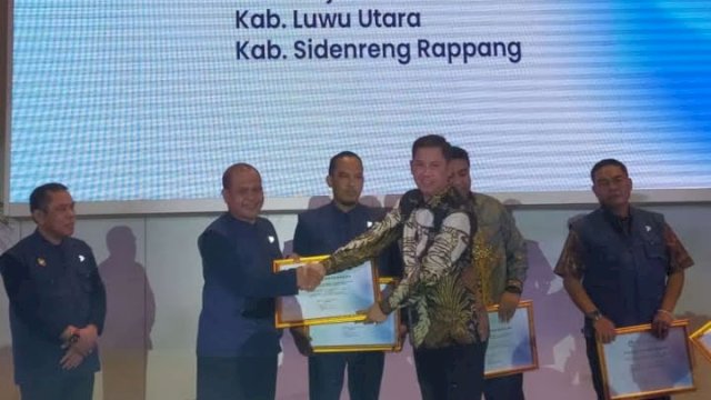 Kepala BBPMP Sulsel, Imran menyerahkan penghargaan ke Kepala Dinas Pendidikan dan Kebudayaan (Kadisdikbud) Luwu Utara, Jasrum pada kegiatan Anugerah Pendidikan yang digelar di Hotel Claro Makassar, Rabu (21/12).