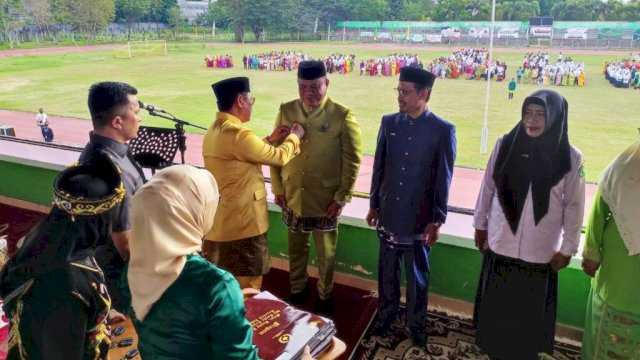 Penjabgub Hamka saat menyematkan tanda penghargaan kepada ASN Kementrian Agama Provinsi Gorontalo dan Kabupaten Kota yang menerima Satya Lancana Karya Satya 10 tahun, 20 tahun dan 30 tahun, pada Peringatan Hari Amal Bhakti (HAB) ke-77 Kementrian Agama RI tingkat Provinsi Gorontalo, bertempat di Lapangan GOR Nani Wartabone, Kota Gorontalo, Selasa (3/1/2023).