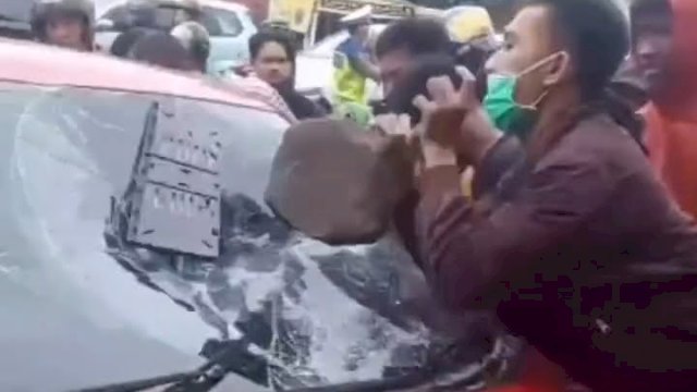 Tangkapan layar sebuah mobil sedan Honda Brio dirusak massa di Kota Makassar, Sabtu (18/2/2023) yang beredar di media sosial.