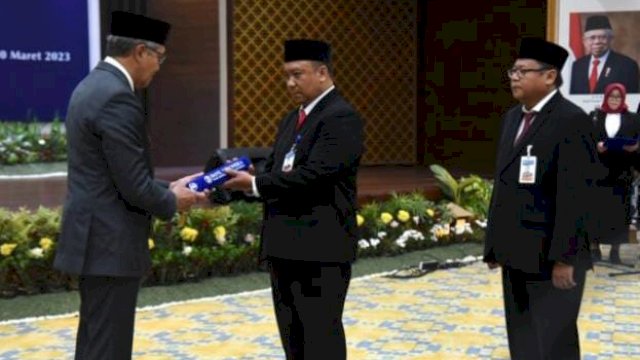 Deputi Gubernur BI, Dody Budi Waluyo, menyerahkan petikan surat keputusan pada pengukuhan Kepala Perwakilan BI Gorontalo, Dian Nugraha, di aula Kantor Perwakilan BI, Jumat (10/3/2023). 