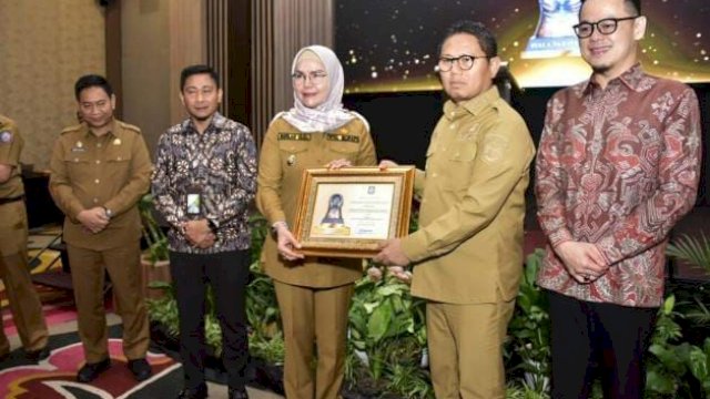 Penjagub Hamka saat menyerahkan piagam penghargaan kepada Wakil Bupati Kabupaten Bone Bolango sebagai pemenang kategori Pemerintah Daerah dalam Penganugerahan Paritrana Award Tahun 2022, Selasa (7/3/2023), di Ballroom Hotel Aston Kota Gorontalo.