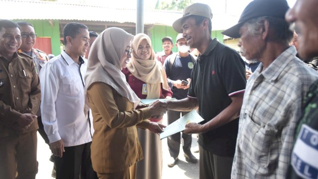 Bupati Luwu Utara, Indah Putri Indriani saat memberikan sertifikat tanah ke masyarakat melalui rogram Redistribusi Tanah Tahun 2022 di Kantor Desa Bantimurung, Selasa (11/04/2023).