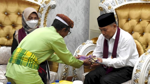 Penjabat Gubernur Gorontalo Ismail Pakaya bersama istri disambut adat mopotilolo saat tiba di VIP bandara lama, Sabtu (13/5/2023). 