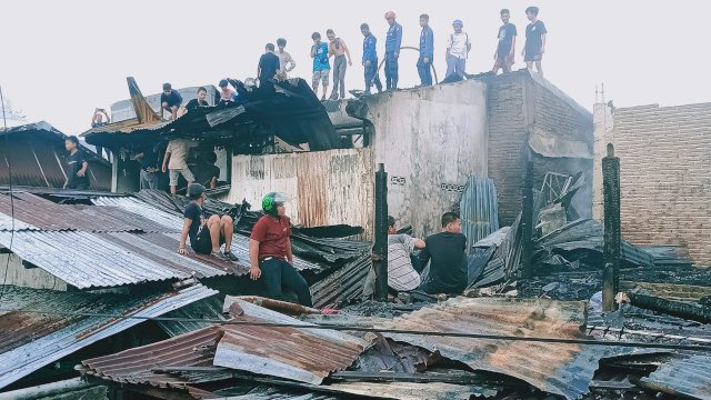 Puluhan warga bersama tim Damkar Makassar tengah berusaha memadamkan api yang melalap sejumlah rumah di Jl Sungai Saddang 1, Kelurahan Balla Parang, Kecamatan Rappocini, Makassar, Senin (19/6/2023). (Abatanews)