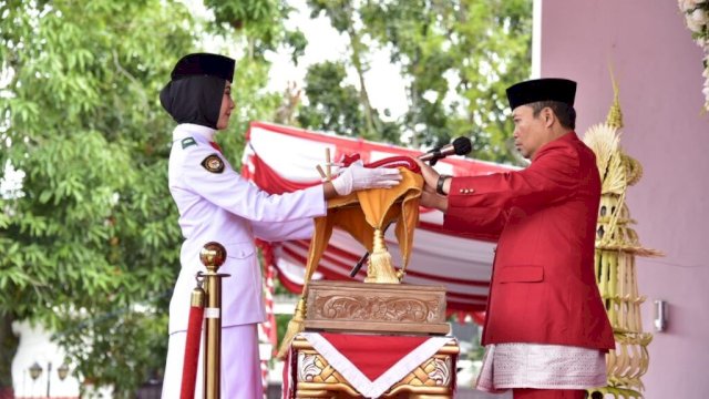 Penjagub Gorontalo Ismail Pakaya saat menerima bendera merah putih dari petugas pembawa baki, pada pelaksanaan Hari Ulang Tahun (HUT) ke-78 Republik Indonesia tingkat Provinsi Gorontalo, yang berlangsung di halaman rumah jabatan Gubernur Gorontalo, Kamis (17/8/2023).