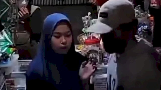 Tangkapan layar yang viral di media sosial saat pelaku perampokan (kanan) beraksi di sebuah warung kelontong do Jl Singa, Kota Makassar beberapa waktu lalu. 