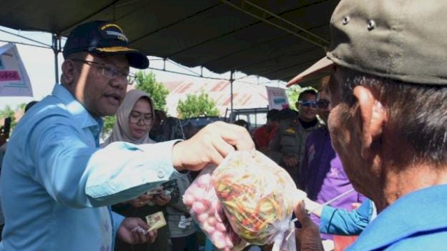 Sekda Provinsi Gorontalo, Sofian Ibrahim, melayani warga yang berbelanja pada pasar murah di Kelurahan Bulota, Kecamatan Limboto, Kabupaten Gorontalo, Minggu (14/4/2024).