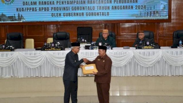 Pj. Gubernur Gorontalo Rudy Salahuddin saat menyerahkan dokumen nota pengantar rancangan Kebijakan Umum Anggaran (KUA) dan Prioritas Plafon Anggaran Sementara (PPAS) Perubahan Anggaran Pendapatan dan Belanja Daerah (APBD-P) Pemprov Gorontalo tahun 2024 kepada Ketua DPRD Paris RA Jusuf, Senin (5/8/2024).