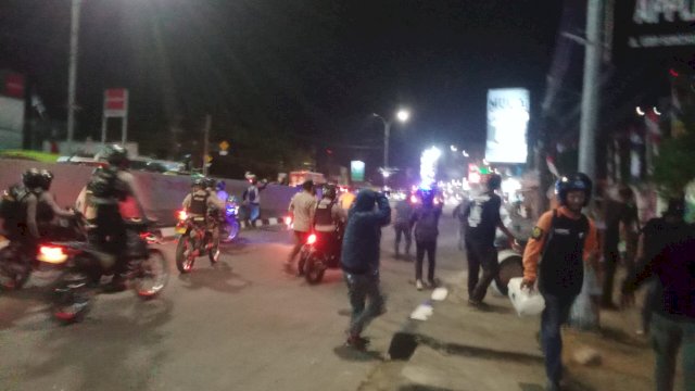 Polisi menggunakan motor mencoba membubarkan aksi demo di depan Kampus Unibos Makassar, Senin malam (26/8/2024). (foto: Abatanews) 