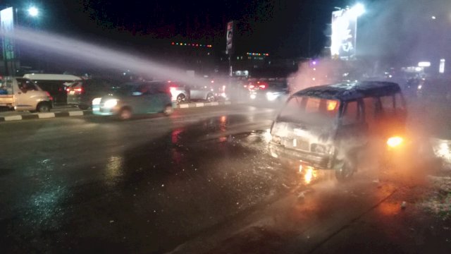 Mobil Rantis Polisi tengah memadamkan api yang melalap angkutan umum yang terbakar saat demo ricuh di Jl Urip Sumoharjo, Makassar, Senin malam (26/8/2024). (Foto: Abatanews)