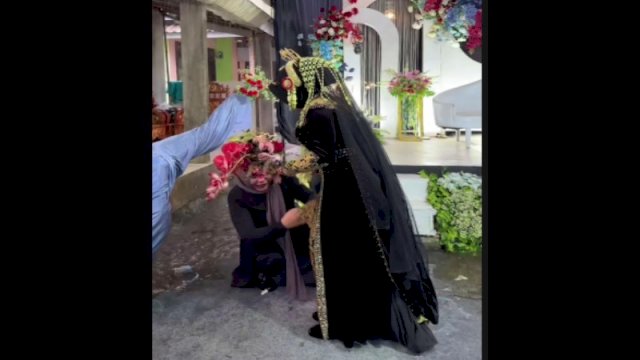 Seorang pengantin wanita lakukan ritual lempar celana dalam ke atap rumah agar hujan reda di hari resepsi. (Foto: Instagram @lambe_turah)