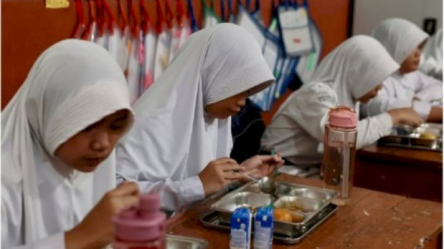 Potret sejumlah anak sekolah menyantap makanan dari Program Makan Bergizi Gratis dari pemerintah. 