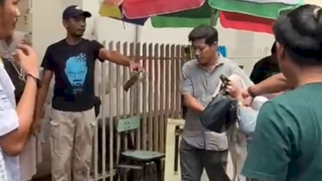 Warga amankan seorang perempuan yang melempar bom molotov di Toko Emas Logam Mulia, Makassar. (foto: Istimewa) 